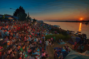 Spectators gather on the banks of the Mekong River to watch the fireballs.